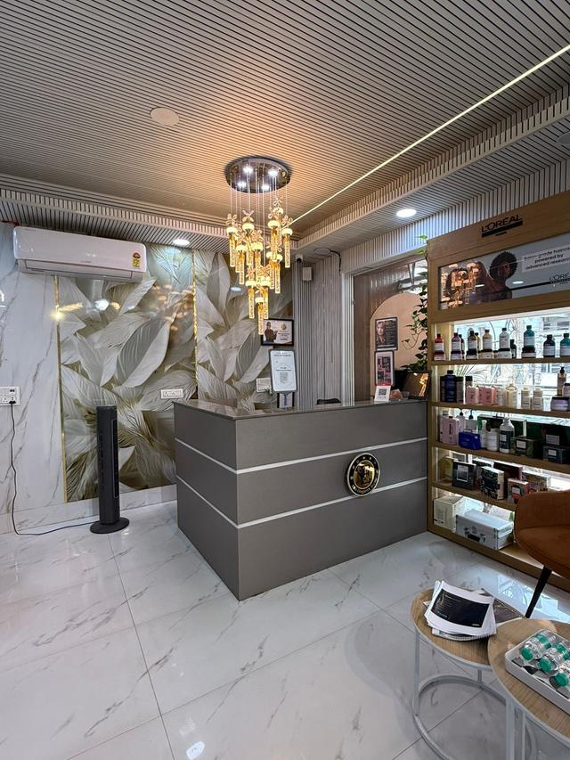 Reception area with a crystal chandelier and a retail shelf of L'Oréal Professionnel hair care products.