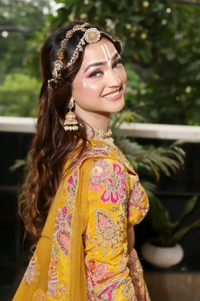Engagement and party makeup with shimmer lilac eyes, glowing skin and a sleek low bun, styled for a pastel lehenga