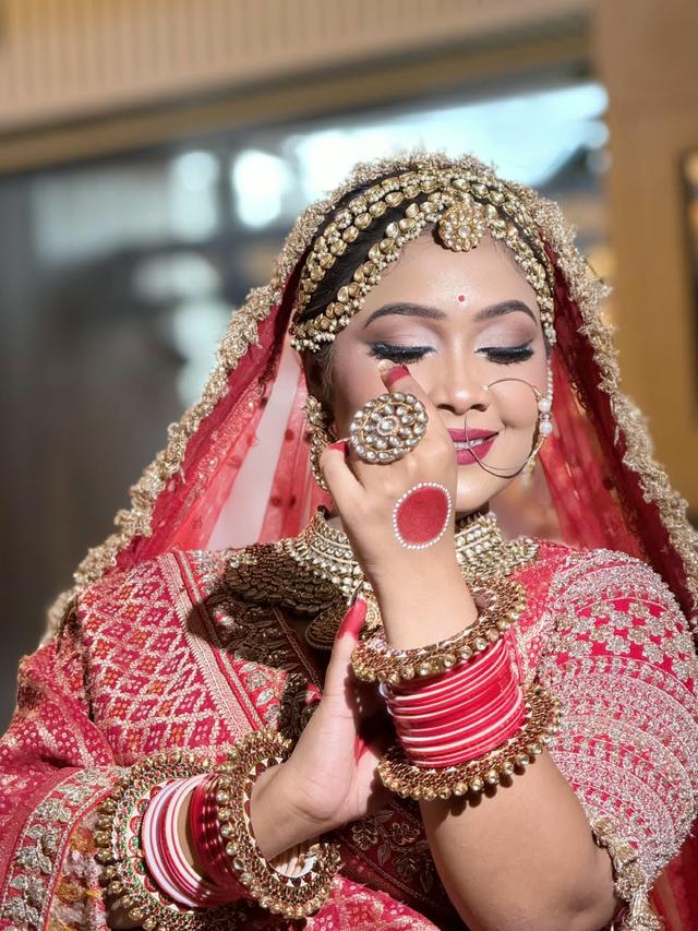 Traditional red bridal makeup with glitter eyes, nude lips and kundan jewellery