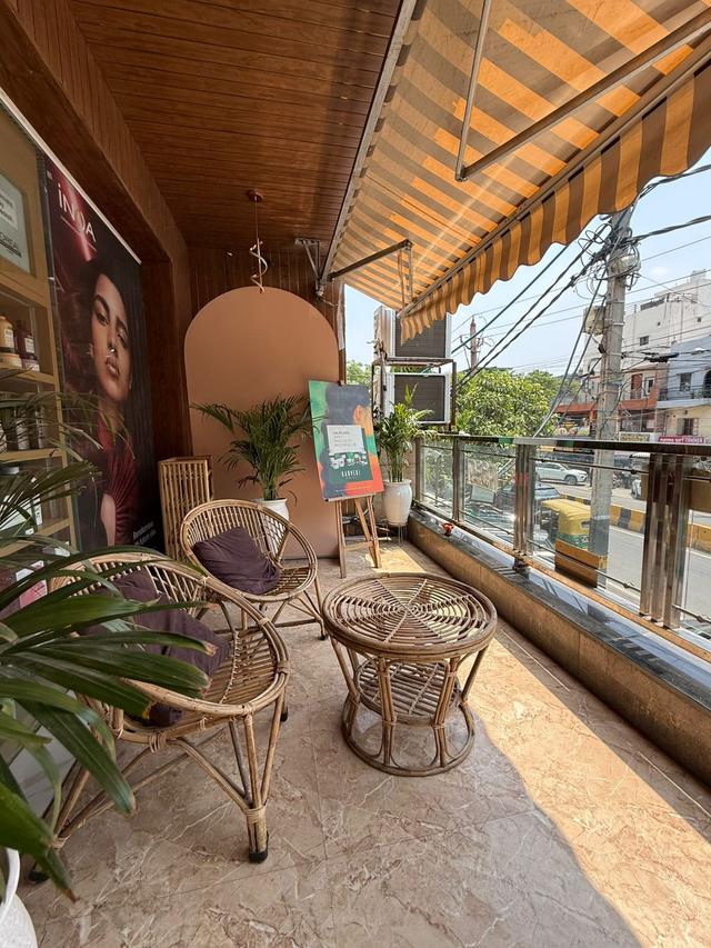 Sunlit balcony lounge for clients to relax before or after their salon appointment in Pitampura, North Delhi