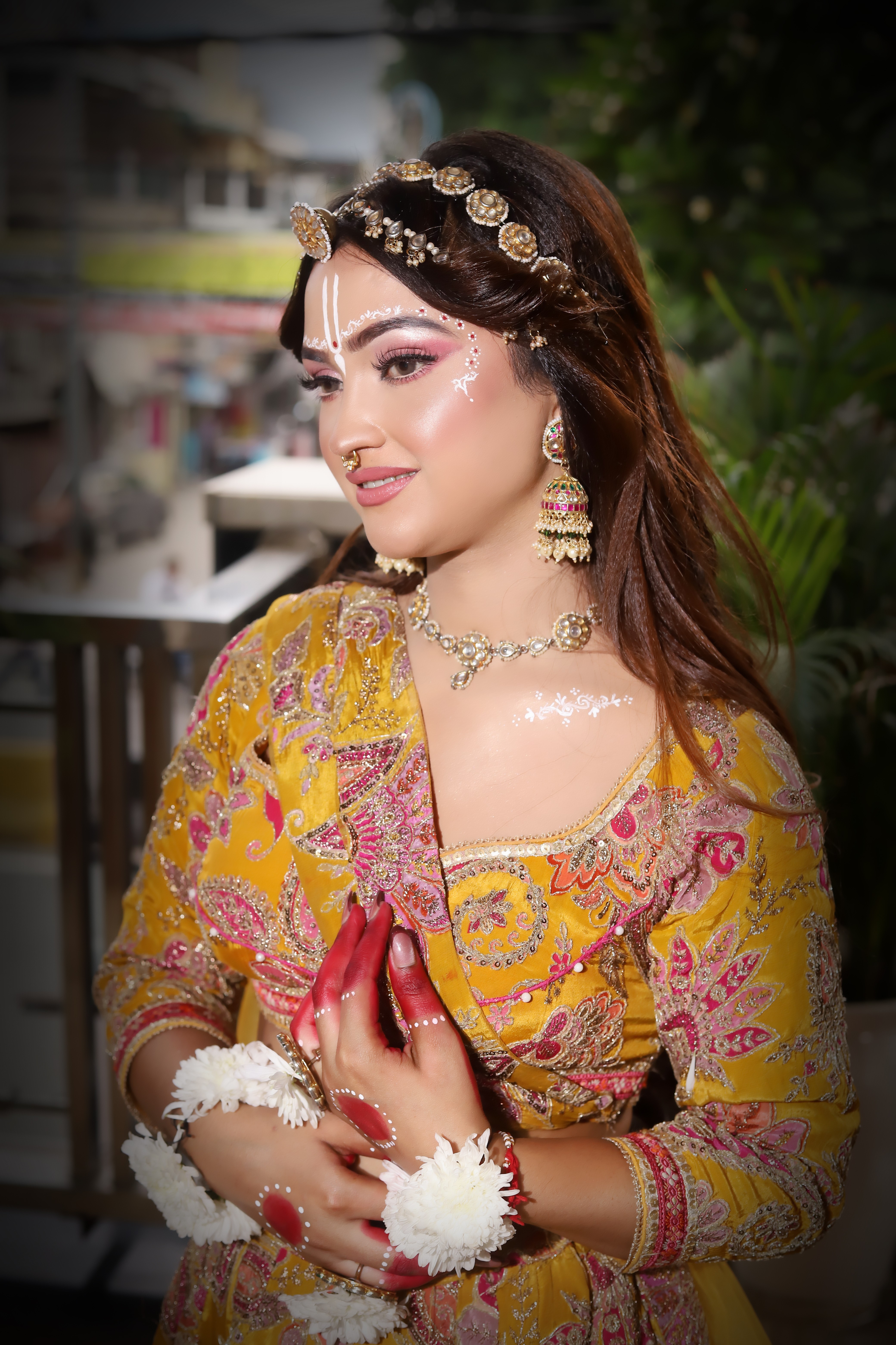 A vibrant festive look with dewy skin, pink-toned eyes and a soft nude lip. Finished with traditional white tilak art and fresh flower jewellery.