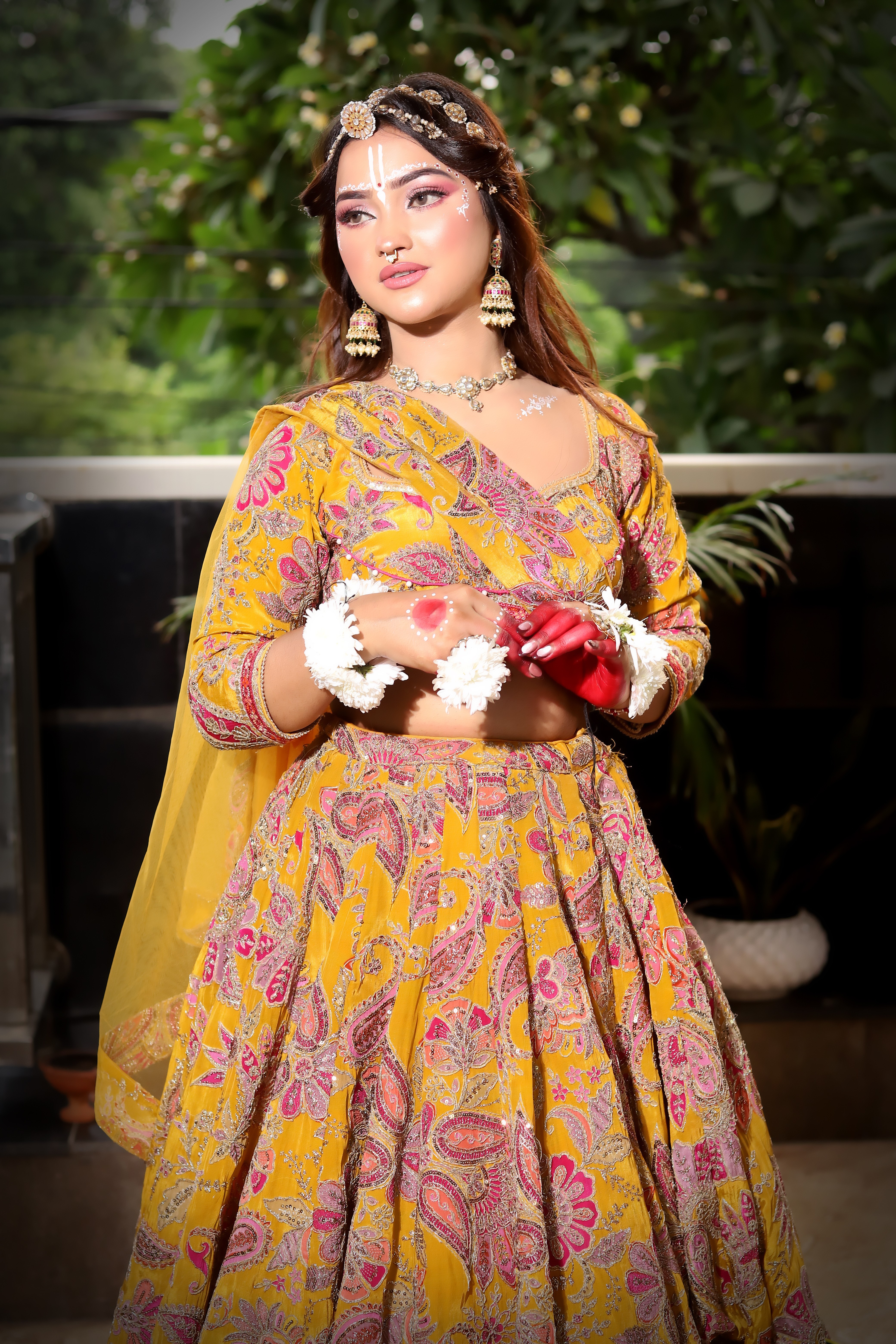 Soft glam party makeup with rosy eyes, glowing skin and delicate white face art. Paired with floral jewellery for a fresh, festive look that shines in every photo.